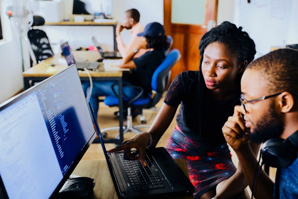 Colleagues collaborating on a laptop in an open office